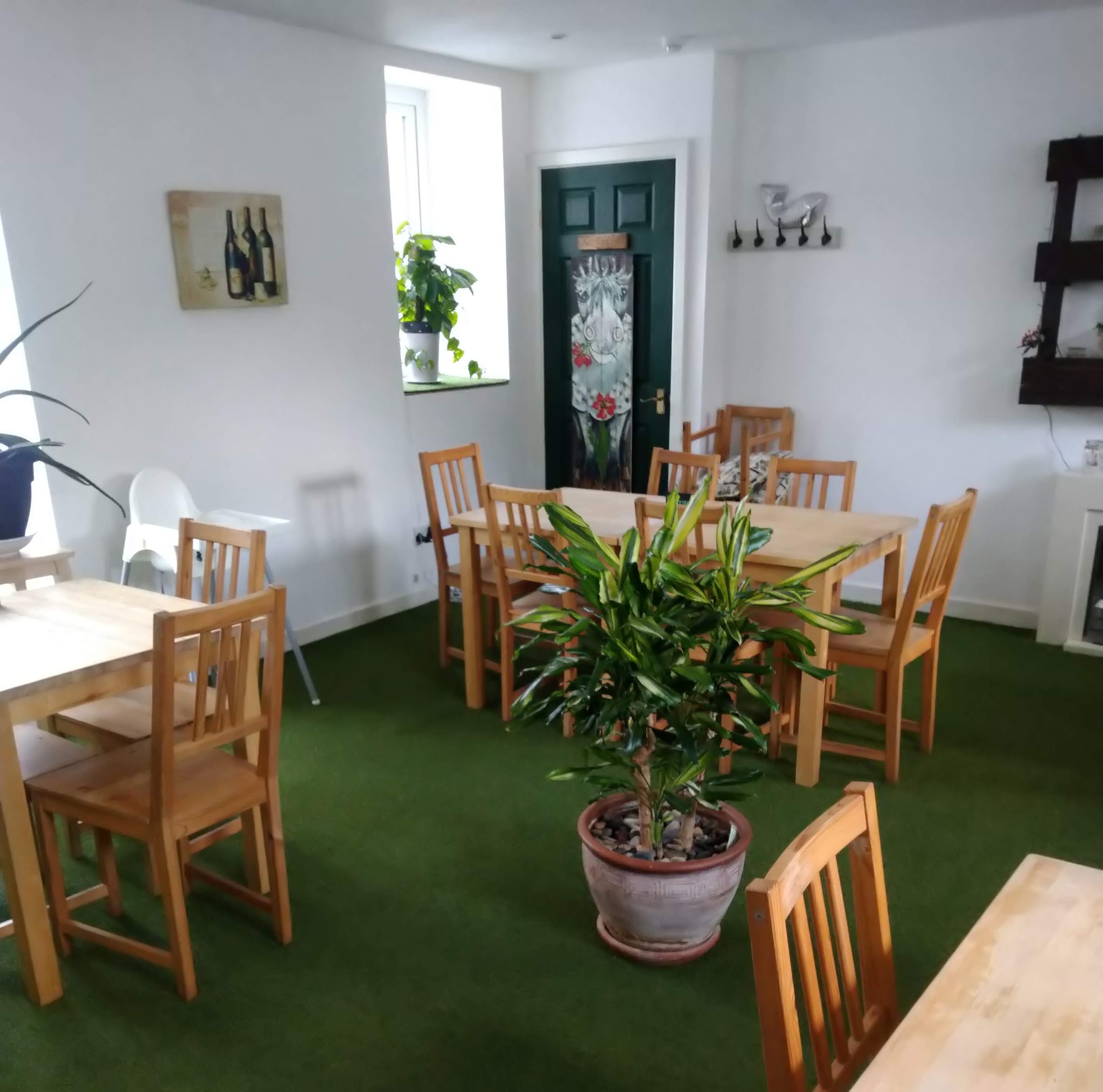 Light-filled dining space with plants, wooden chairs and tables