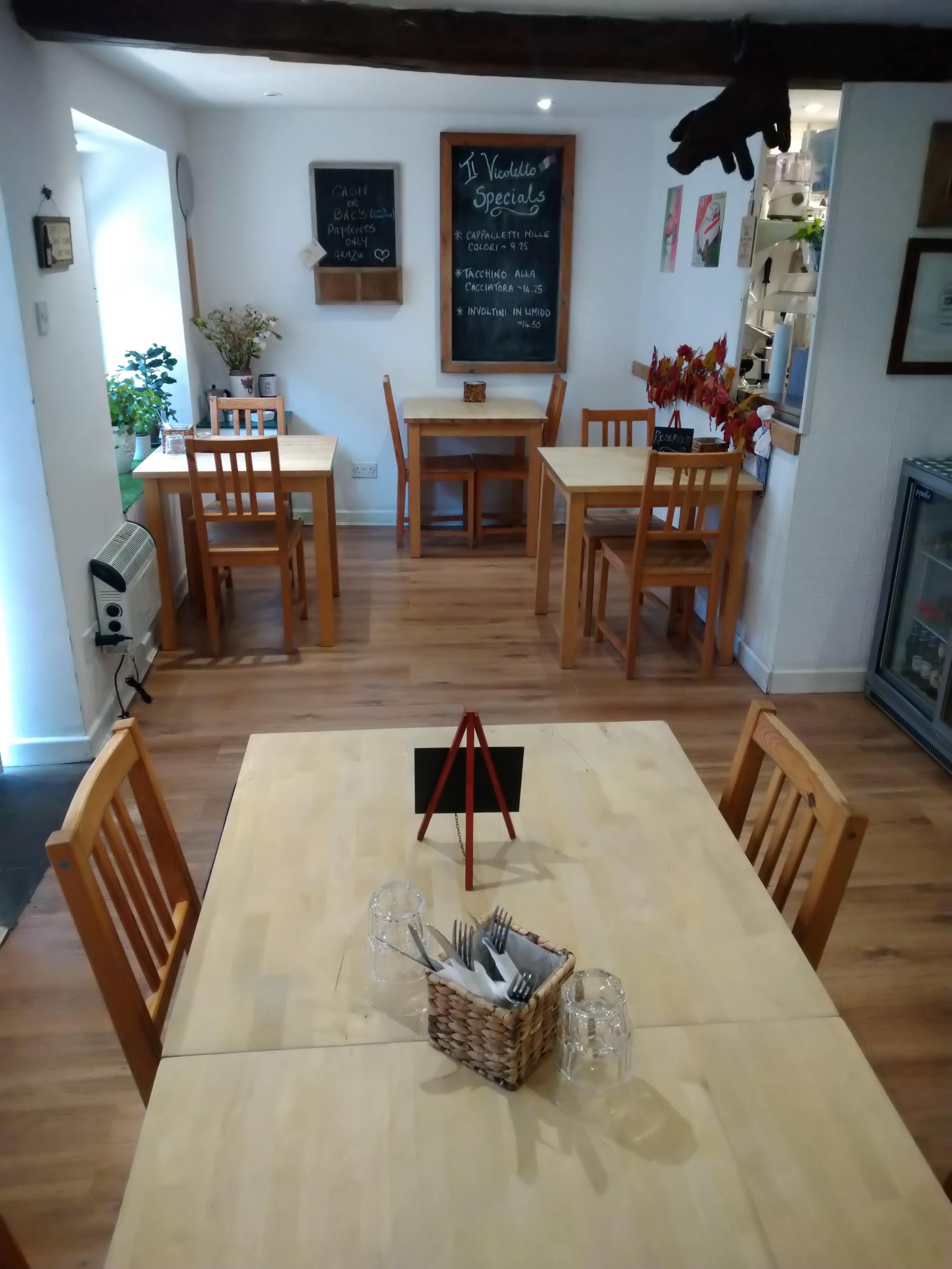 The intimate dining room with wooden tables and a handwritten specials board